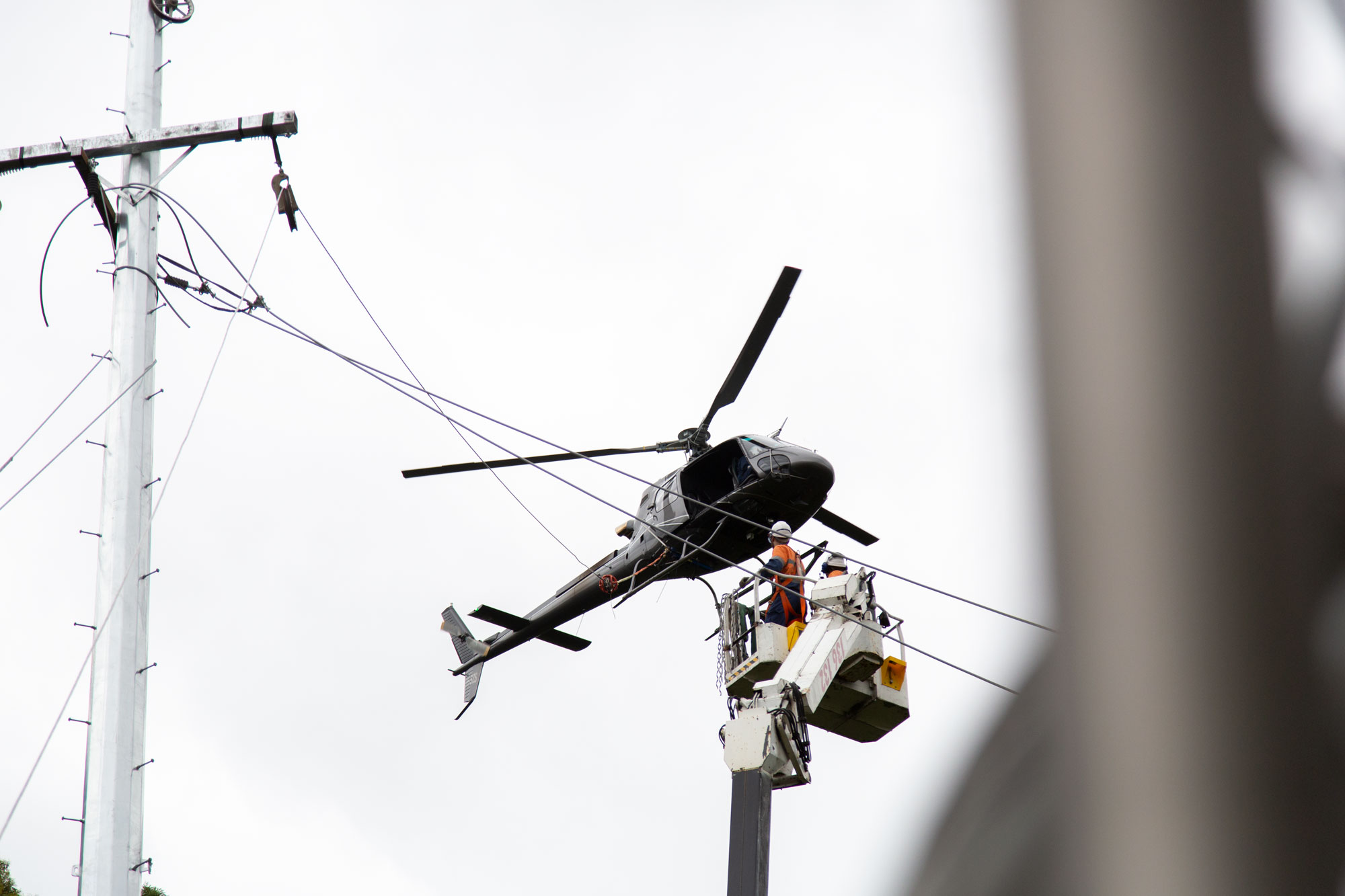 ARA Electrical. Electrician in cherry picker with helicopter support at Mount Keira Power Supply Project